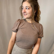 Bubble sleeve sweater top with an adorable tie detailing in the back. Top is a taupe color.